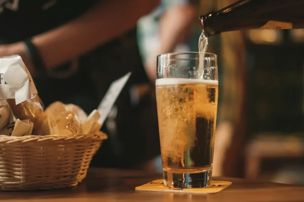 Golden-amber beer with a foamy head pours into a cold glass.