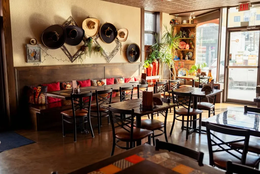 Mexican-themed restaurant interior featuring red booth, sombreros, and dark wood furniture.