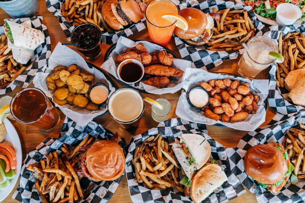 Large spread of American comfort food and drinks on a wooden table.