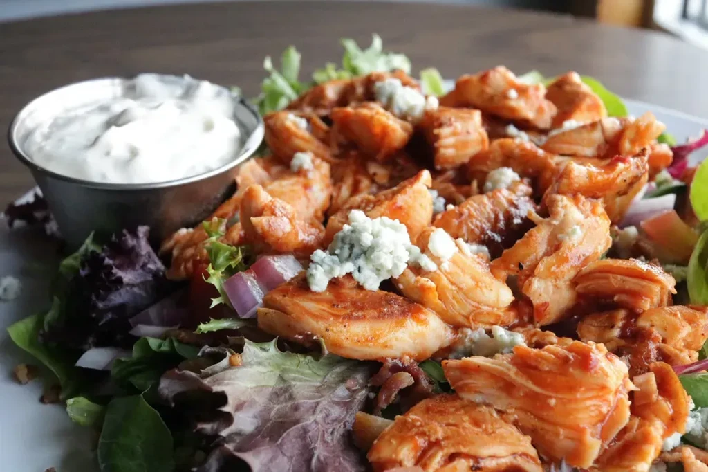 Buffalo chicken salad with blue cheese, mixed greens, and dressing.