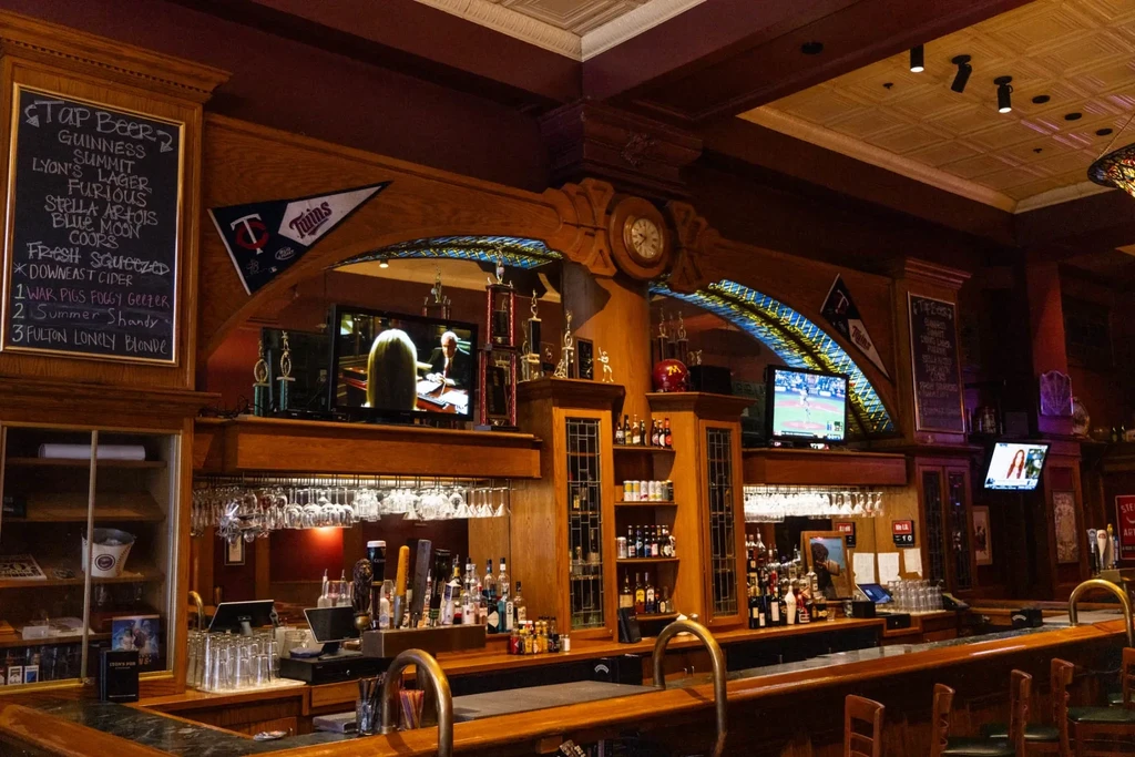 Ornate, classic bar interior with sports memorabilia and drinks.
