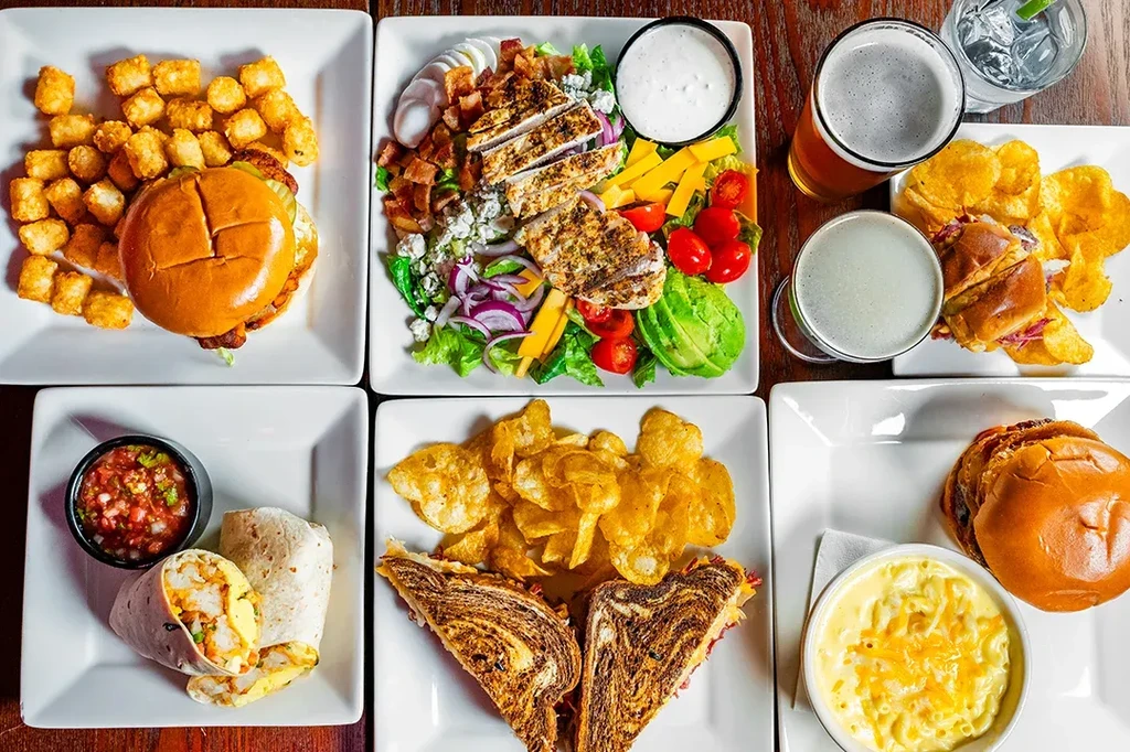 An overhead view of six diverse restaurant dishes and drinks.