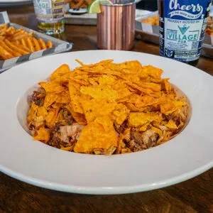 Close-up of nachos in a white bowl at a casual pub.