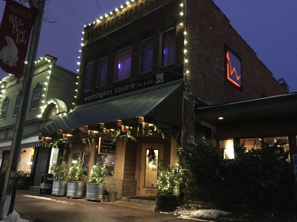 Washington Square bar & grill, covered in string lights on a snowy night.
