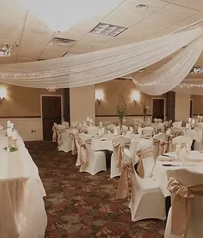 Elegantly decorated banquet hall with round tables and warm lighting.