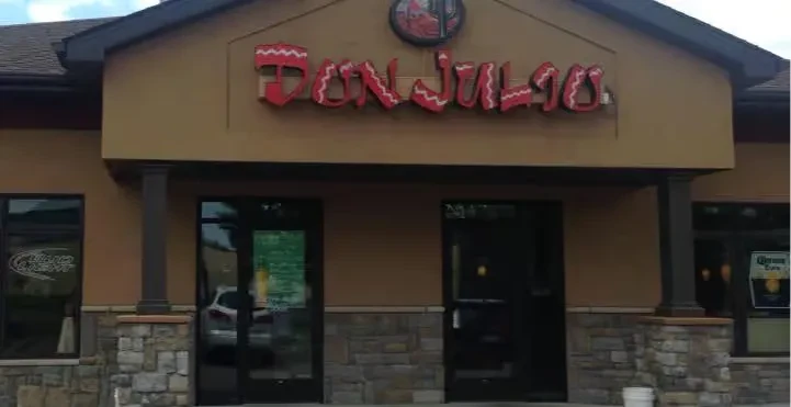 Don Julio restaurant exterior with tan, stone facade and red sign.