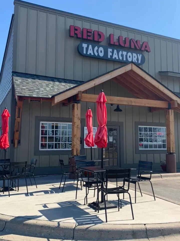 Red Luna Taco Factory exterior, sunny patio with red umbrellas.