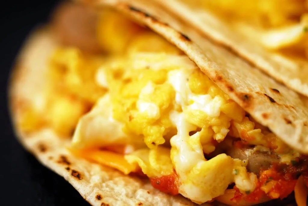 Warm tortilla filled with scrambled eggs and melted cheese.