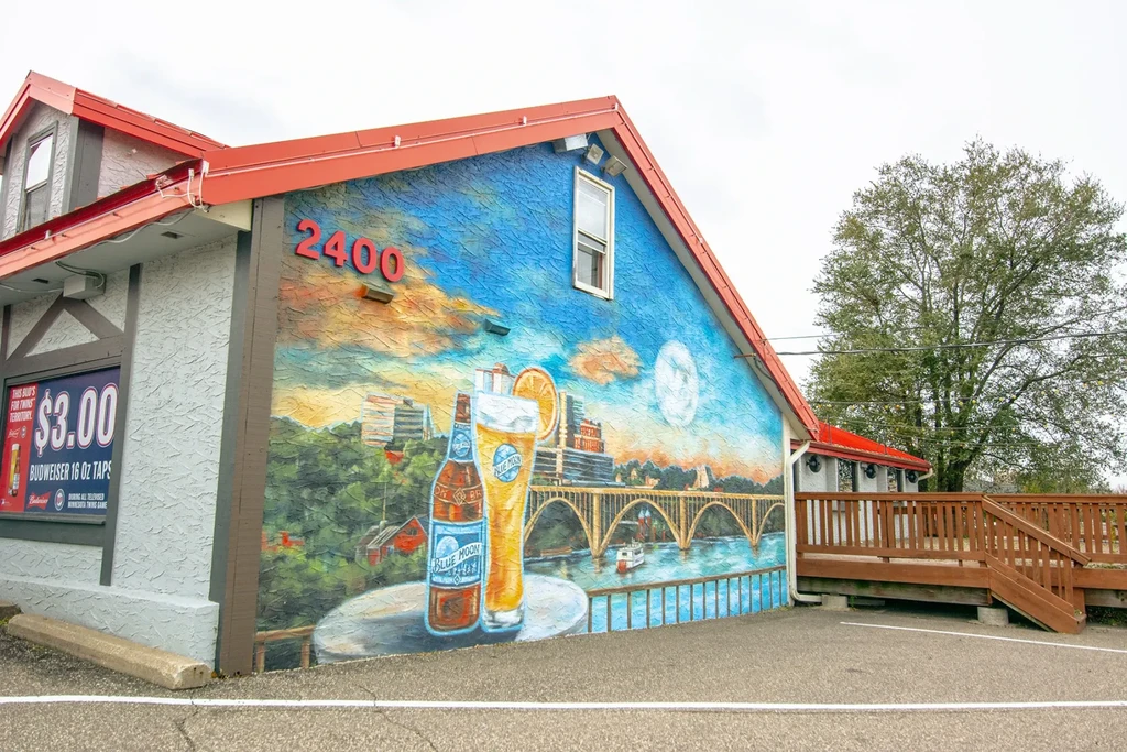 Vibrant Blue Moon beer mural on a red-roofed building with patio.