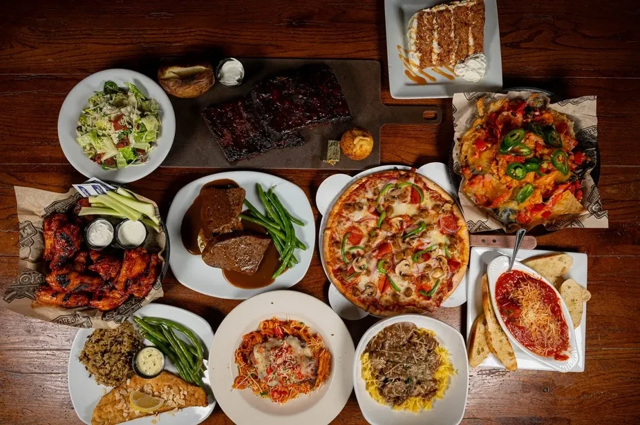 Overhead view of diverse comfort food dishes on a rustic table.