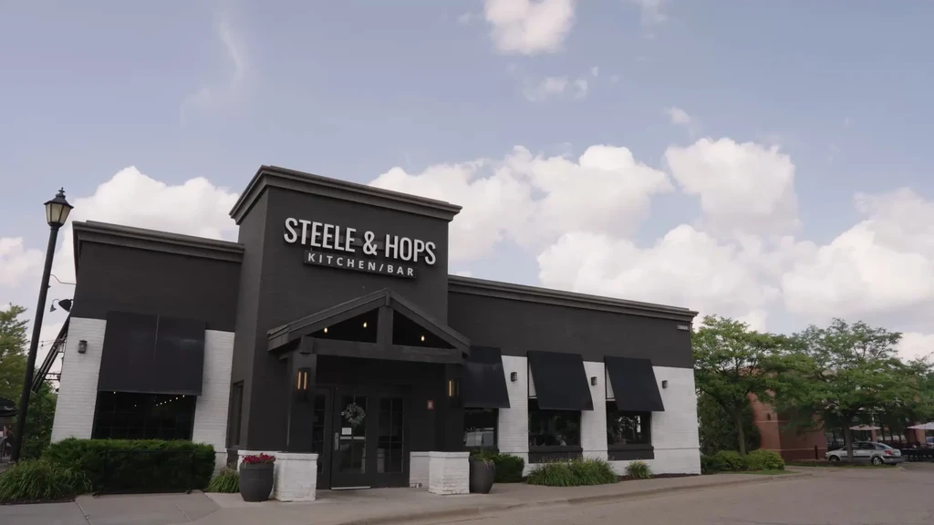 Modern STEELE & HOPS KITCHEN/BAR building exterior on a sunny day.