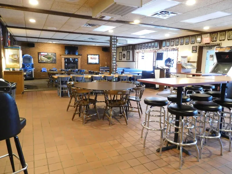 Interior of a casual pub with dining tables, games, and jukebox.