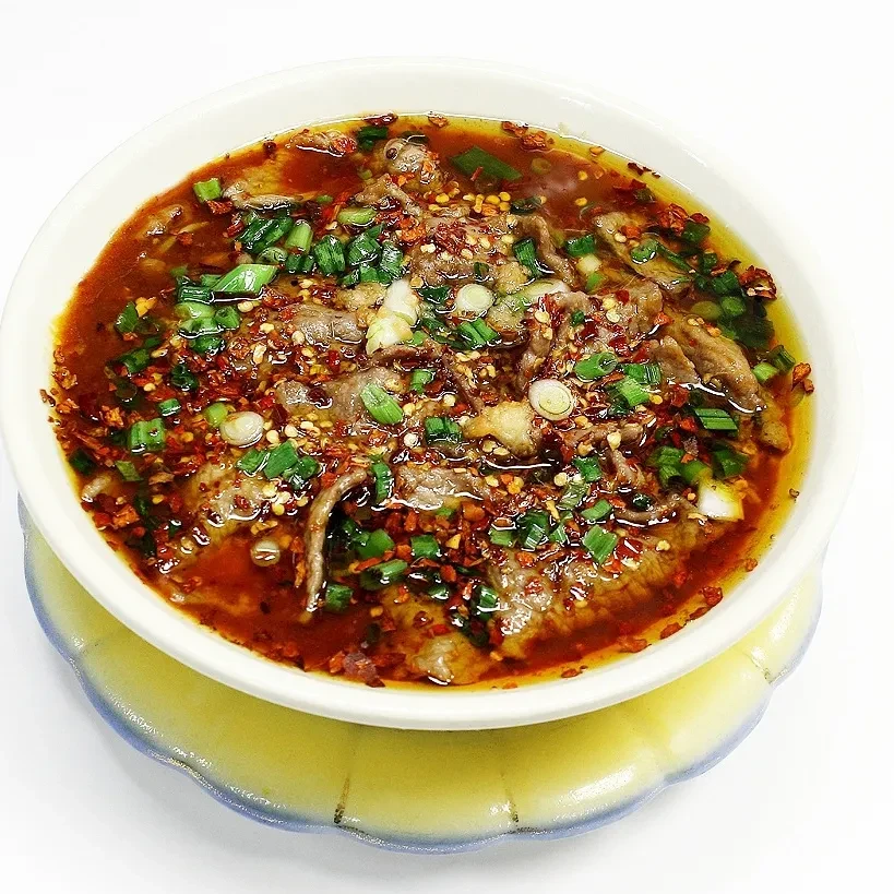 Top-down view of spicy Asian beef stew with scallions and chili flakes.