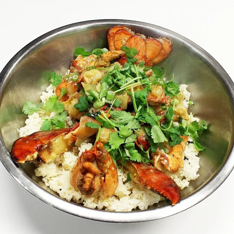 White rice topped with seasoned lobster and fresh green herbs.