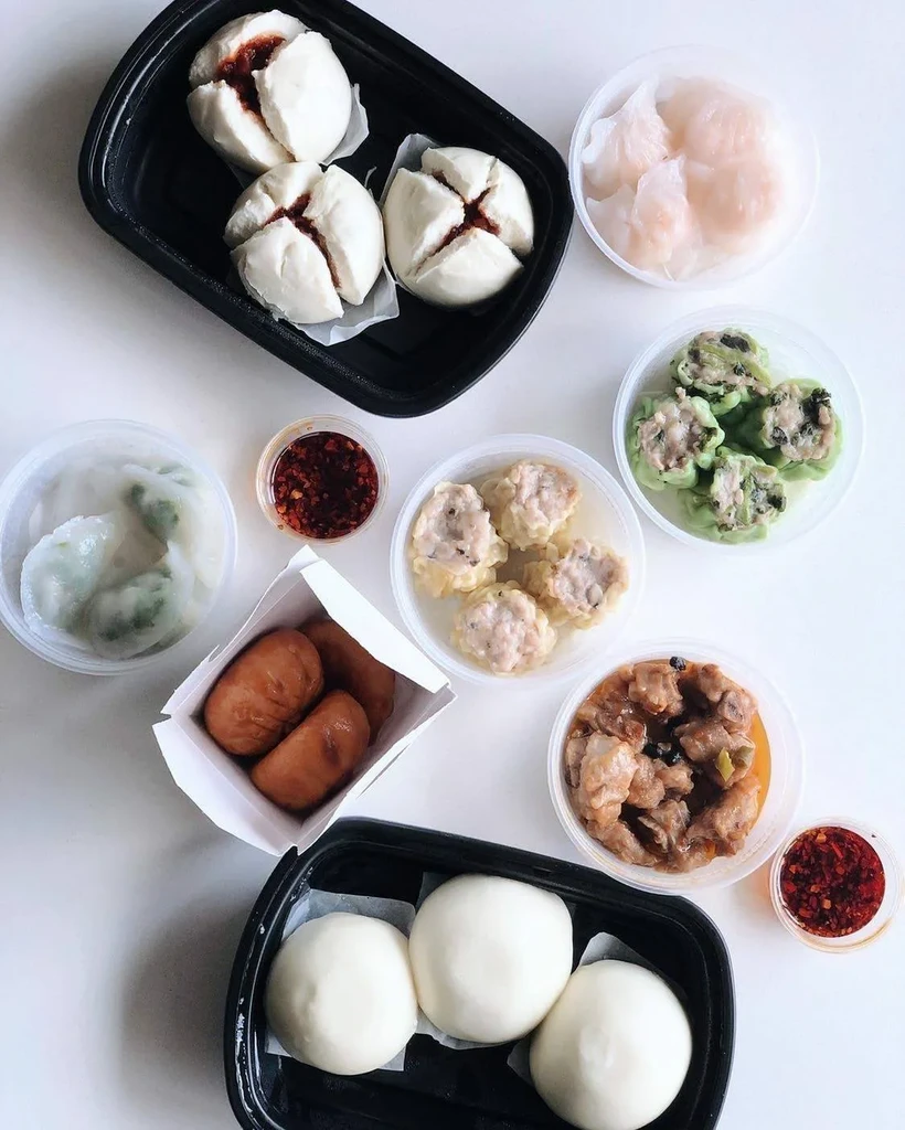 Overhead photo of assorted Chinese dim sum and takeout dishes.