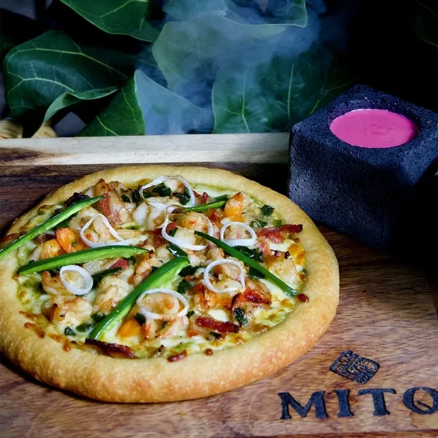 Artisanal shrimp, chili, and onion pizza on a 'MITO' board.