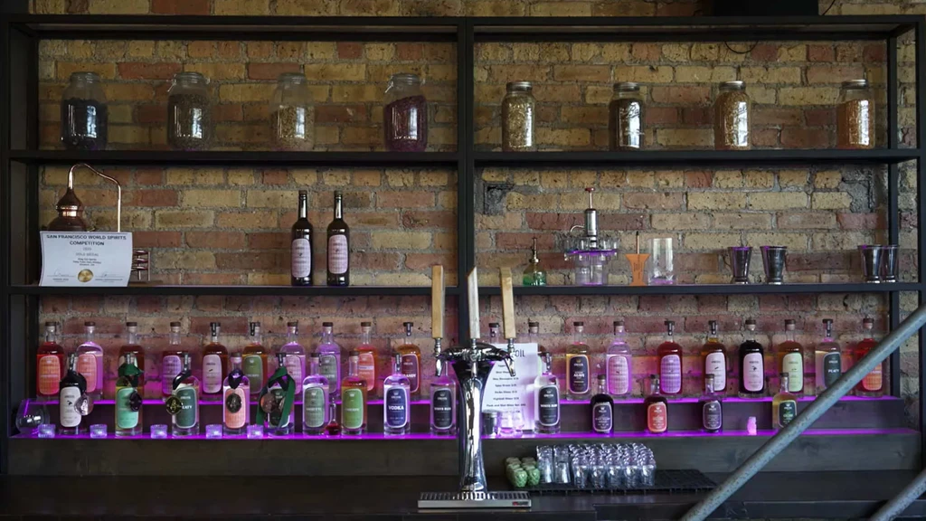 Shelves of illuminated spirits, bar equipment, beer taps, and a competition award.