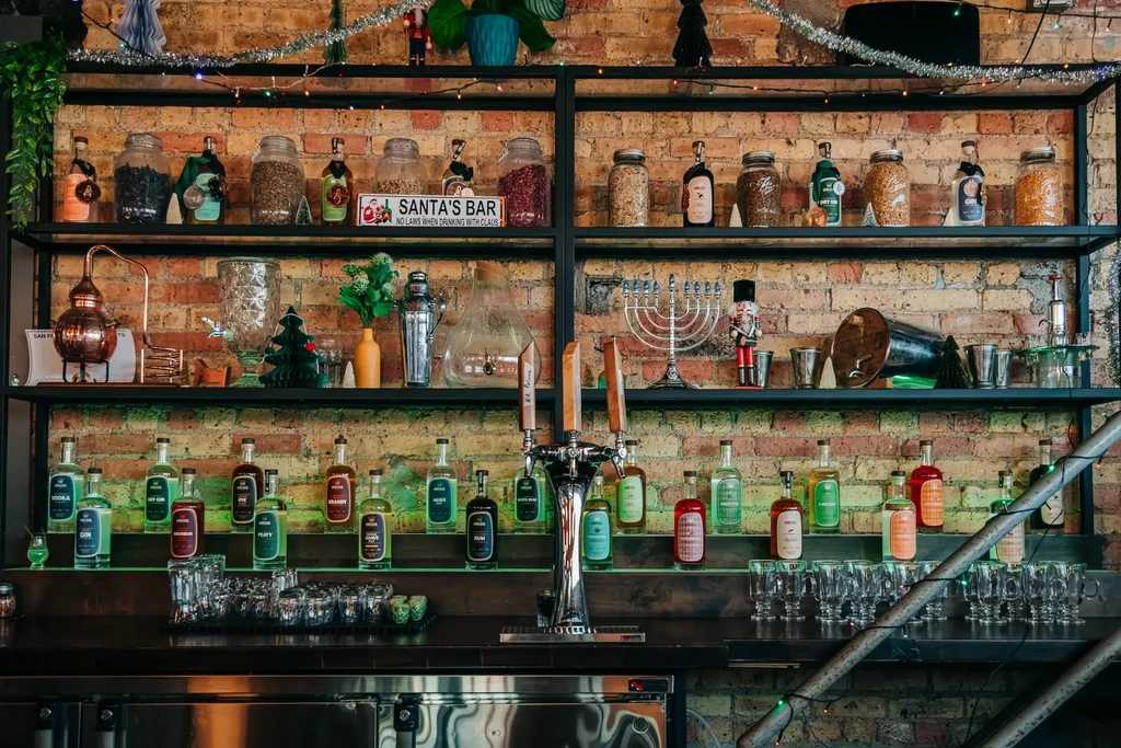 Festive bar shelves showcasing liquor bottles, tap, and holiday decorations.