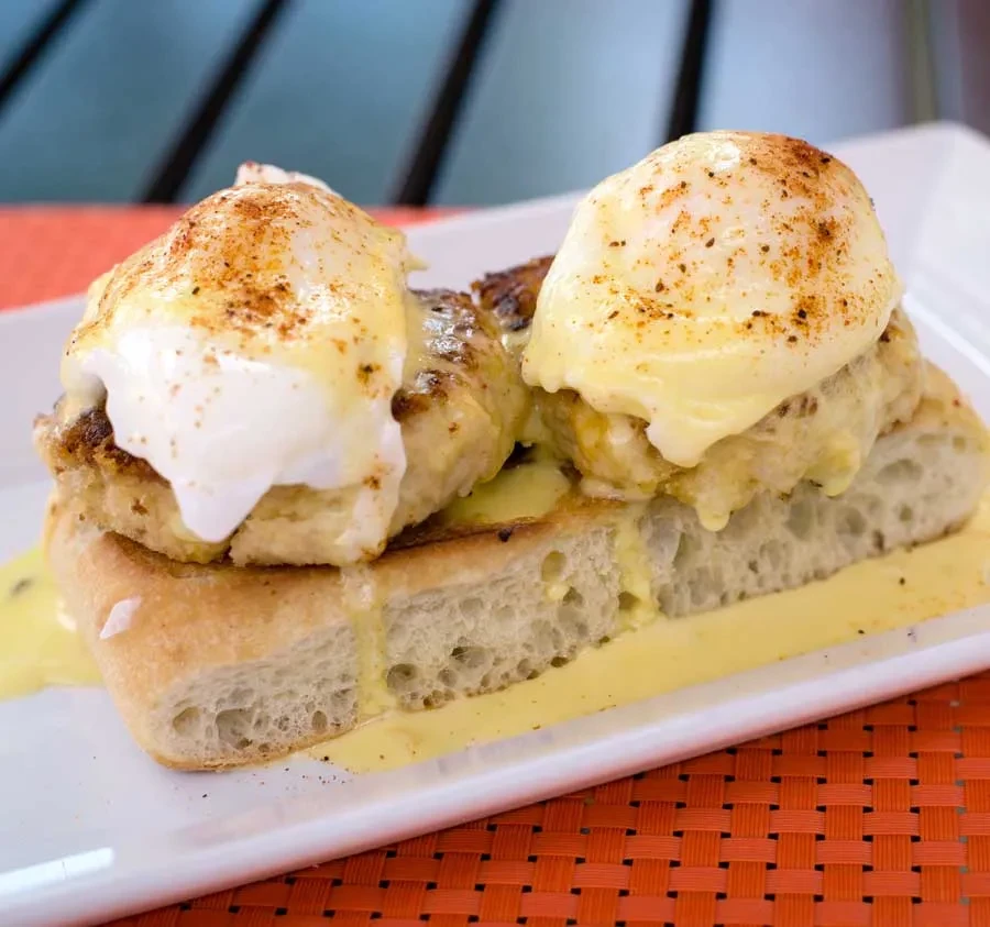 Poached eggs with spiced hollandaise on savory patties and toasted bread.