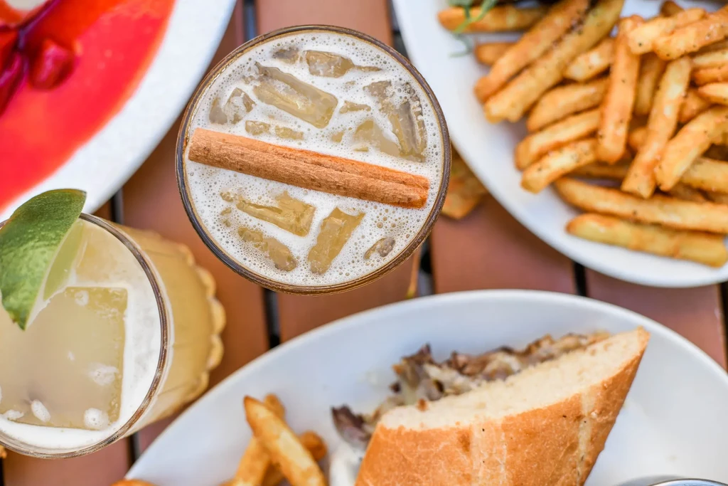 Overhead food spread: sandwiches, fries, and two iced drinks.