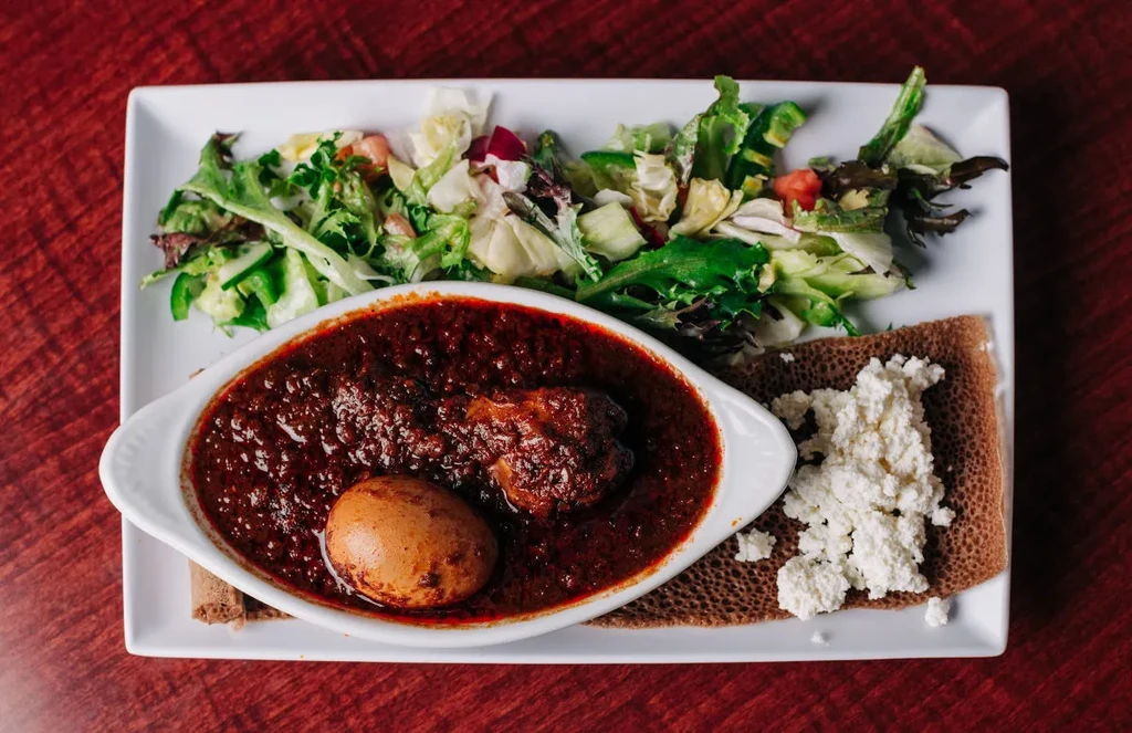 Ethiopian Doro Wat, injera with ayib, and a fresh green salad.