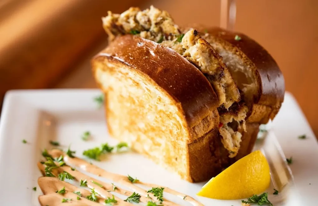 Close-up of a crab roll in brioche, with lemon and parsley.