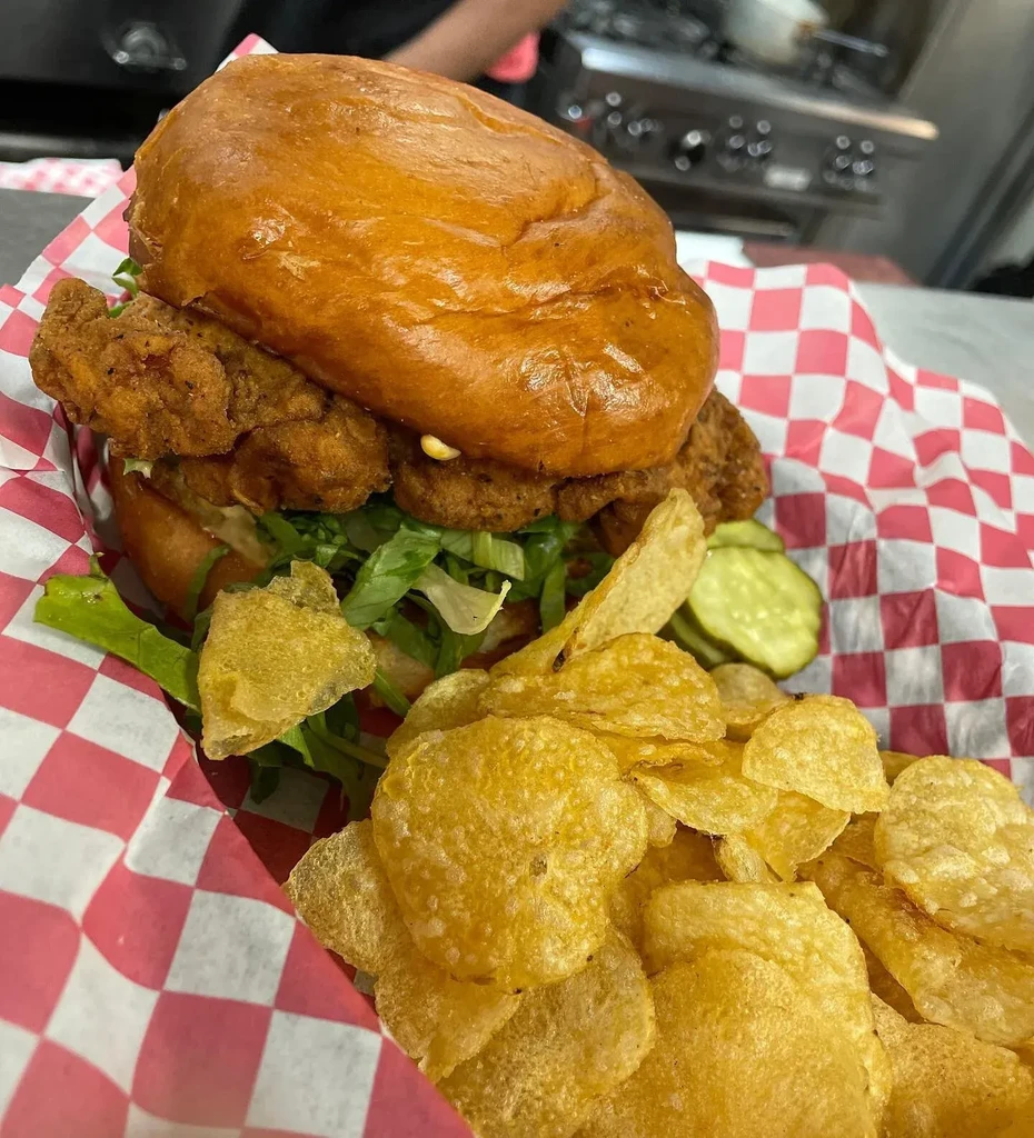 Crispy fried chicken sandwich, potato chips, and pickles.