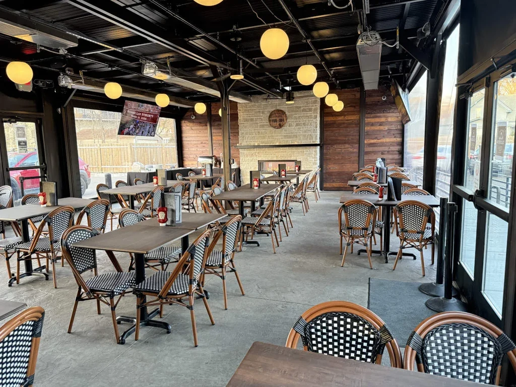 Modern rustic restaurant dining area with empty tables and industrial decor.
