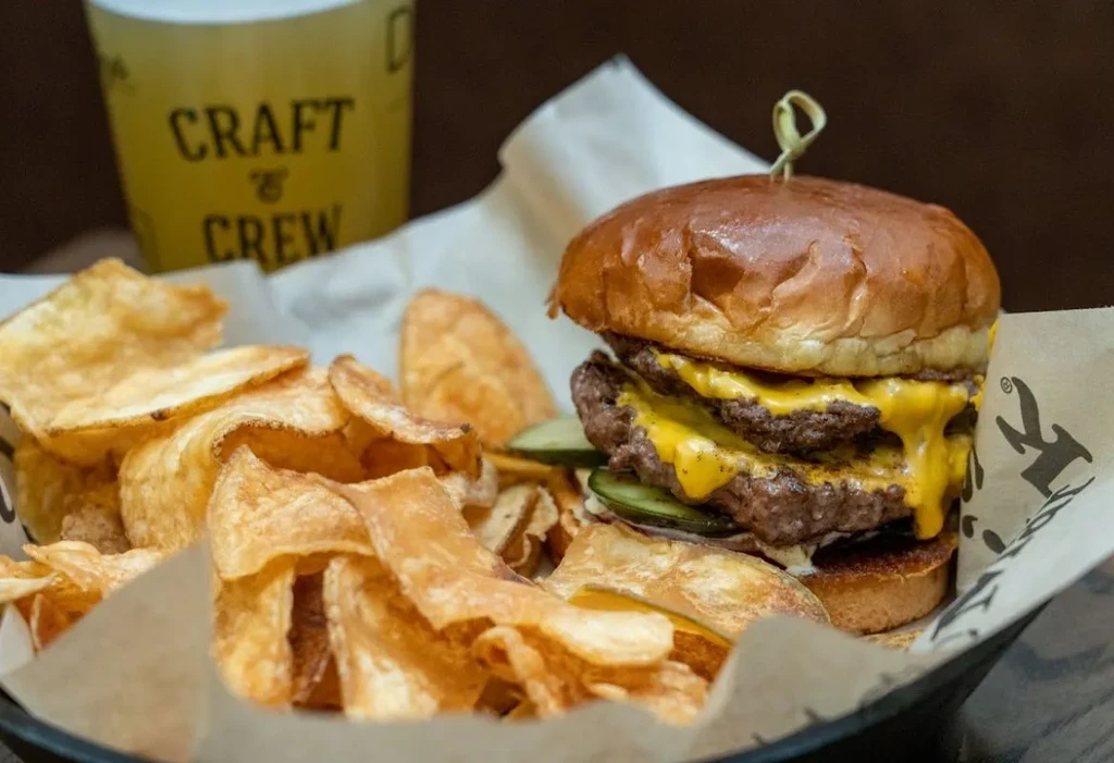 Double cheeseburger, crispy chips, and a branded 'CRAFT & CREW' cup.