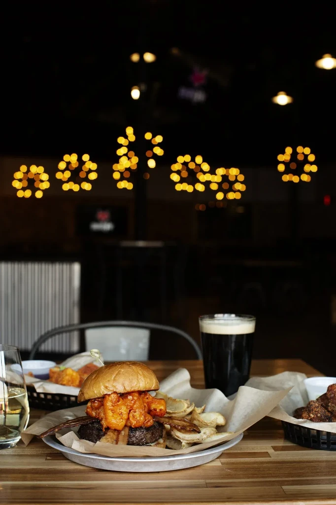 Burger with saucy shrimp, potato chips, white wine, and dark beer.