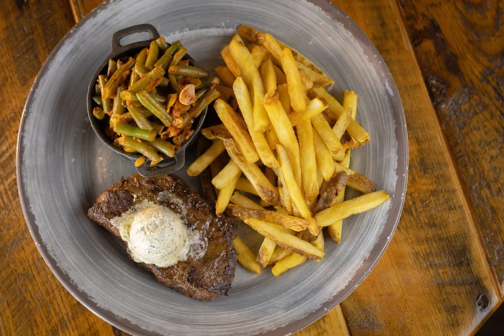 Grilled steak, hand-cut fries, and sautéed green beans meal.