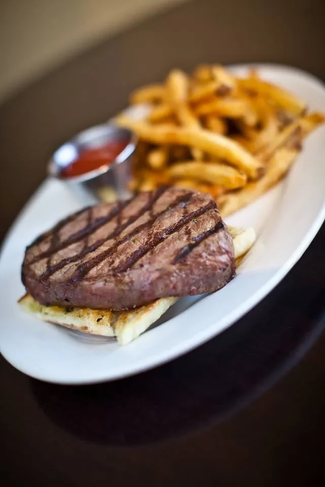 Grilled steak with prominent grill marks, toast, ketchup, and fries.