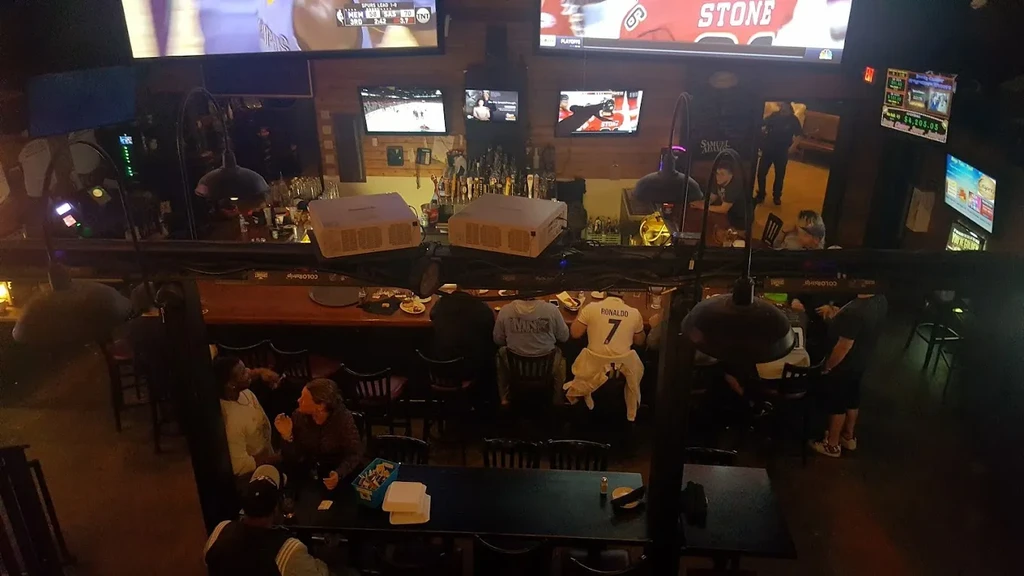 Elevated view of a bustling sports bar with patrons and TVs.