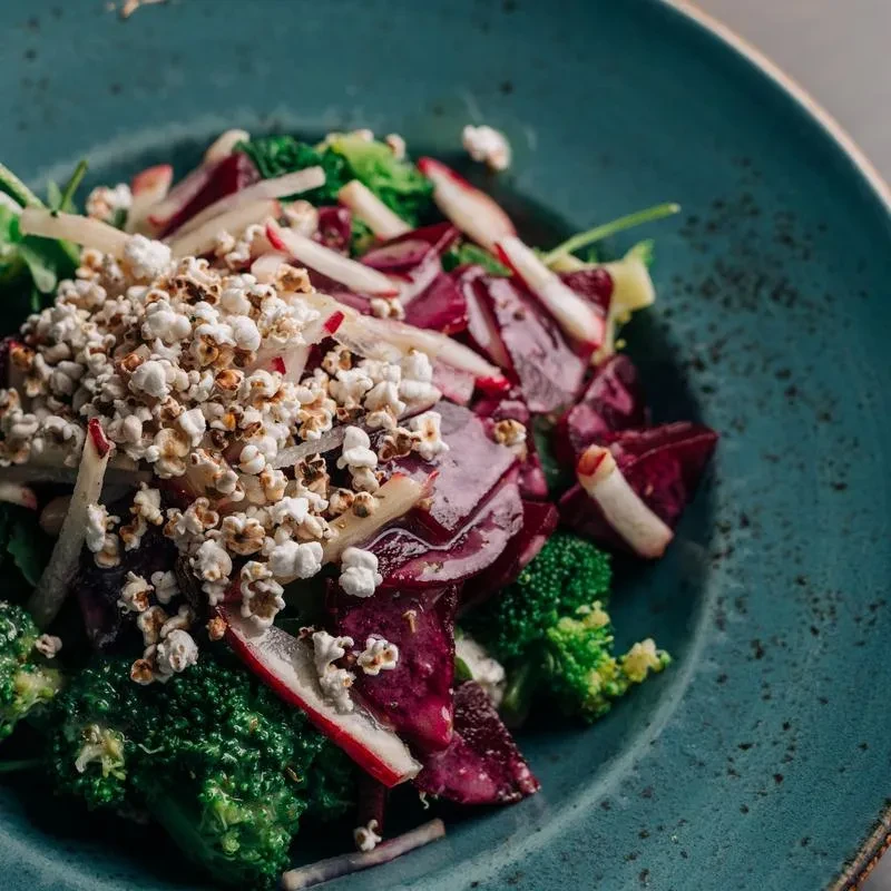 Gourmet salad with broccoli, purple cabbage, radishes, and puffed grains.