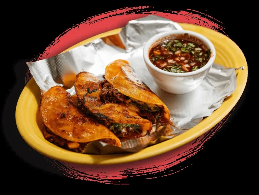 Three crispy birria tacos with consommé in a yellow serving basket.