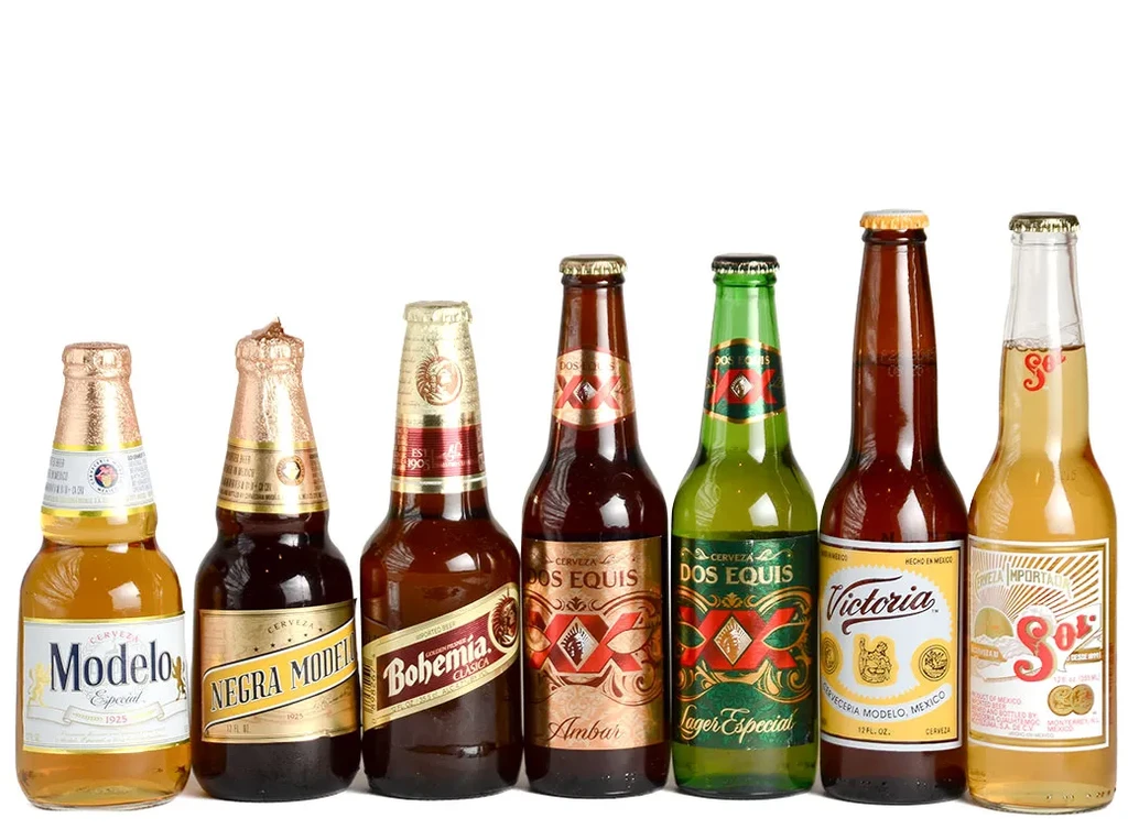 Seven distinct Mexican beer bottles lined up on a white background.