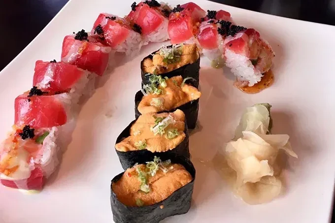 Platter of tuna maki, uni gunkan sushi, and pickled ginger.