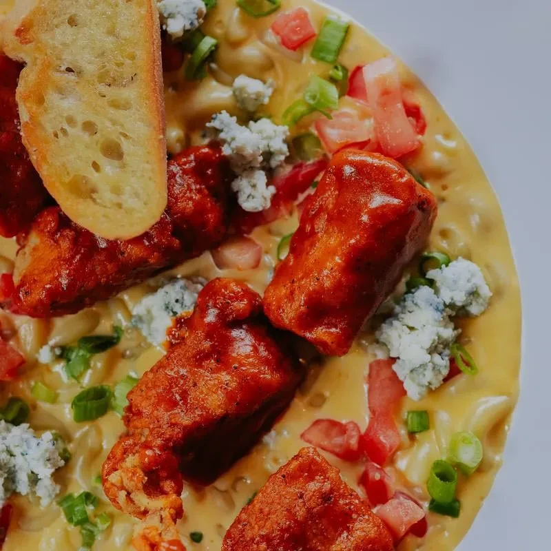 Overhead buffalo chicken mac and cheese, blue cheese, tomatoes, scallions.