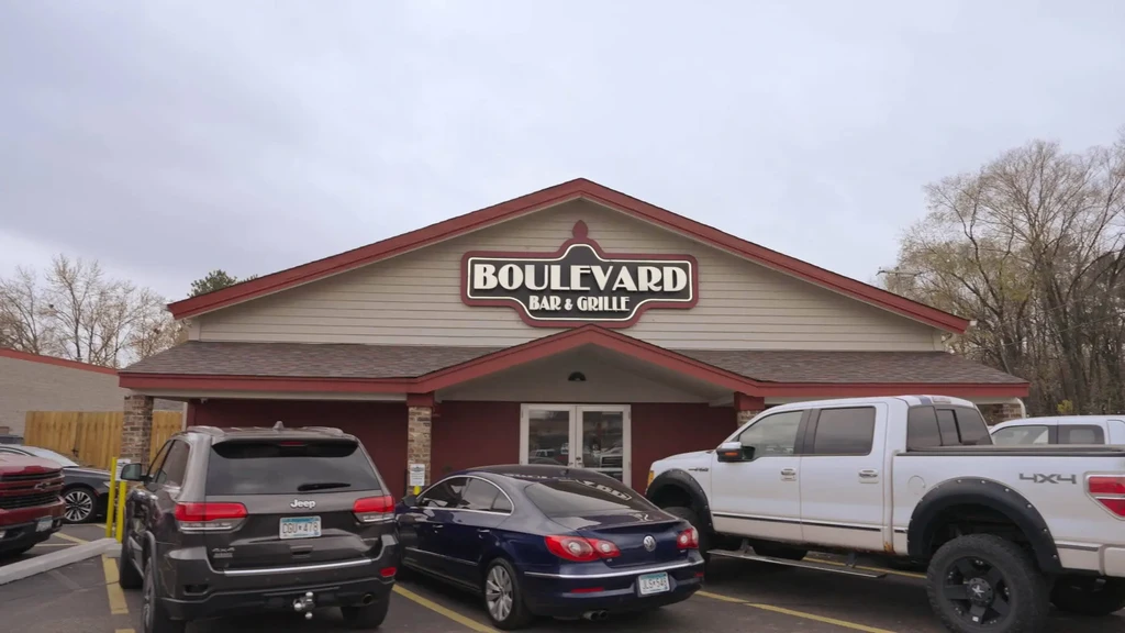 Boulevard Bar & Grille building with parked cars under overcast sky.