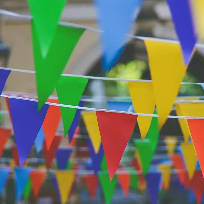 Red, yellow, green, blue pennant flags in rows, shallow depth.