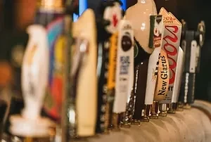 Sharp close-up of bar taps, including Coors Light and New Glarus.