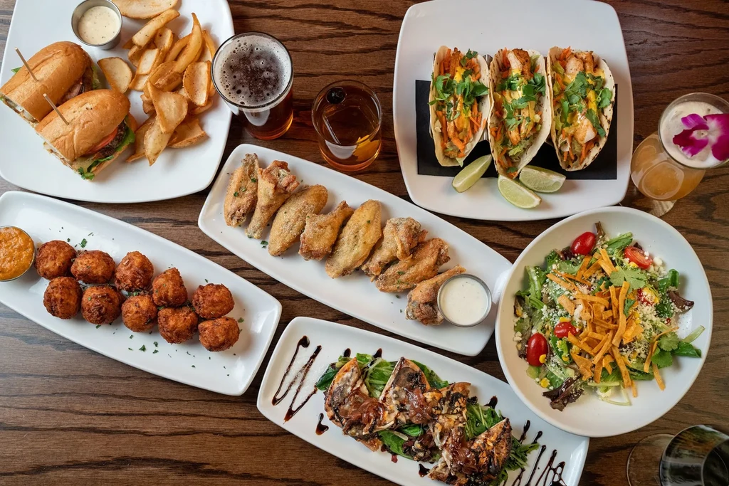 Overhead view of a dark wooden table with various dishes and drinks.