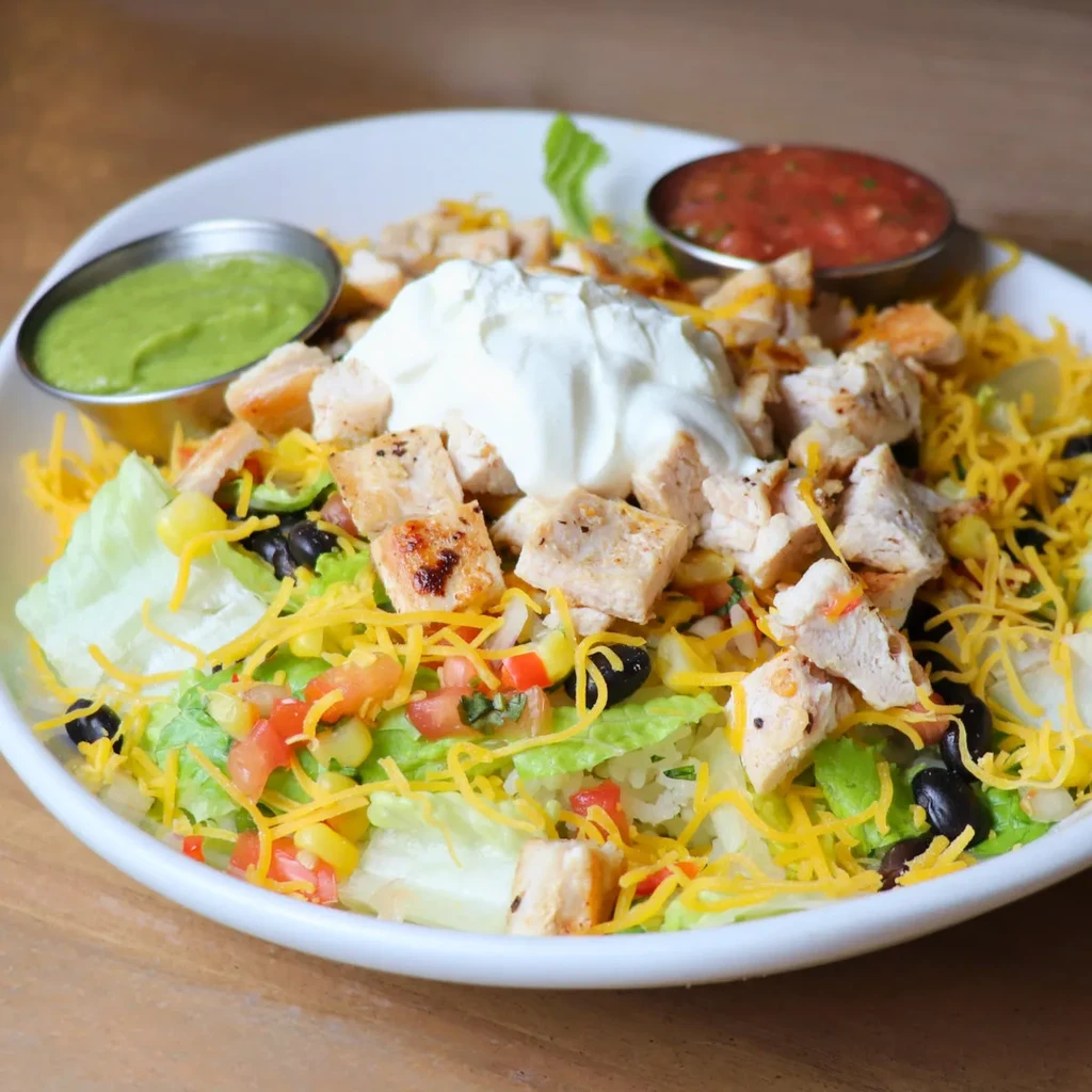 Fresh chicken salad with grilled chicken, cheese, beans, corn, and dips.