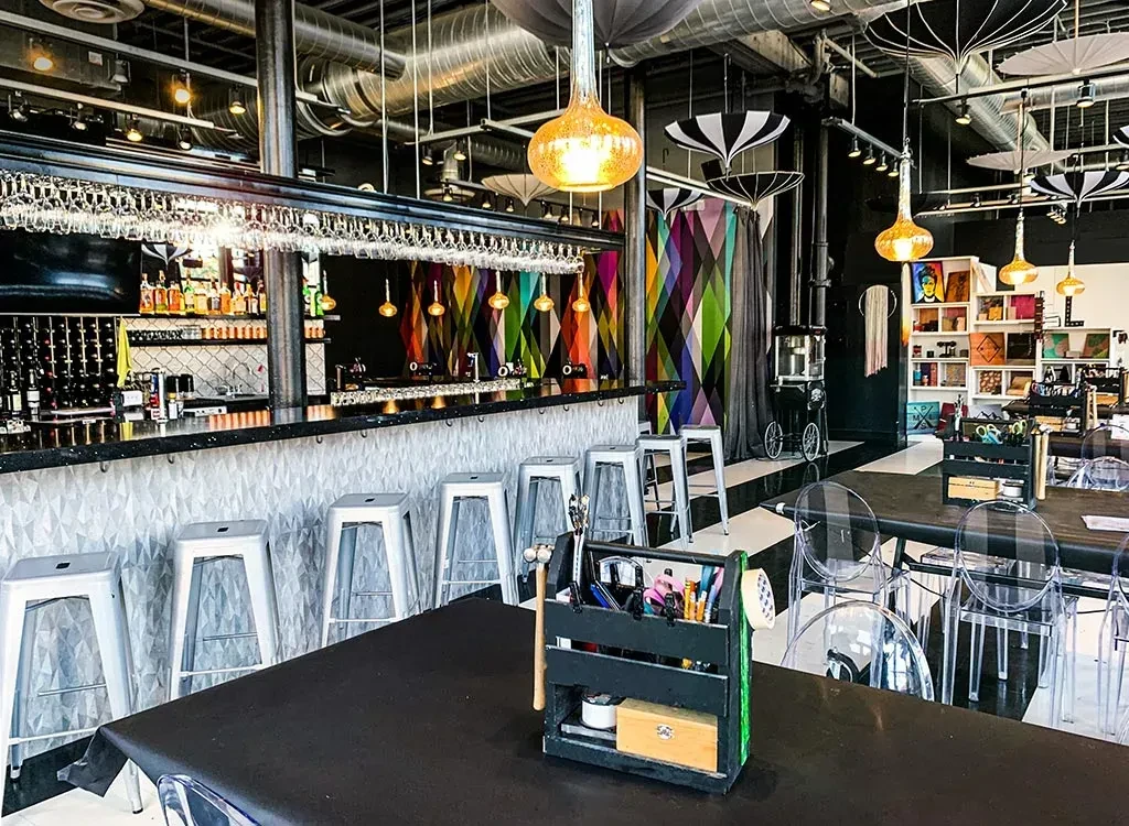 Artistic bar and restaurant with colorful geometric patterns and craft supplies.