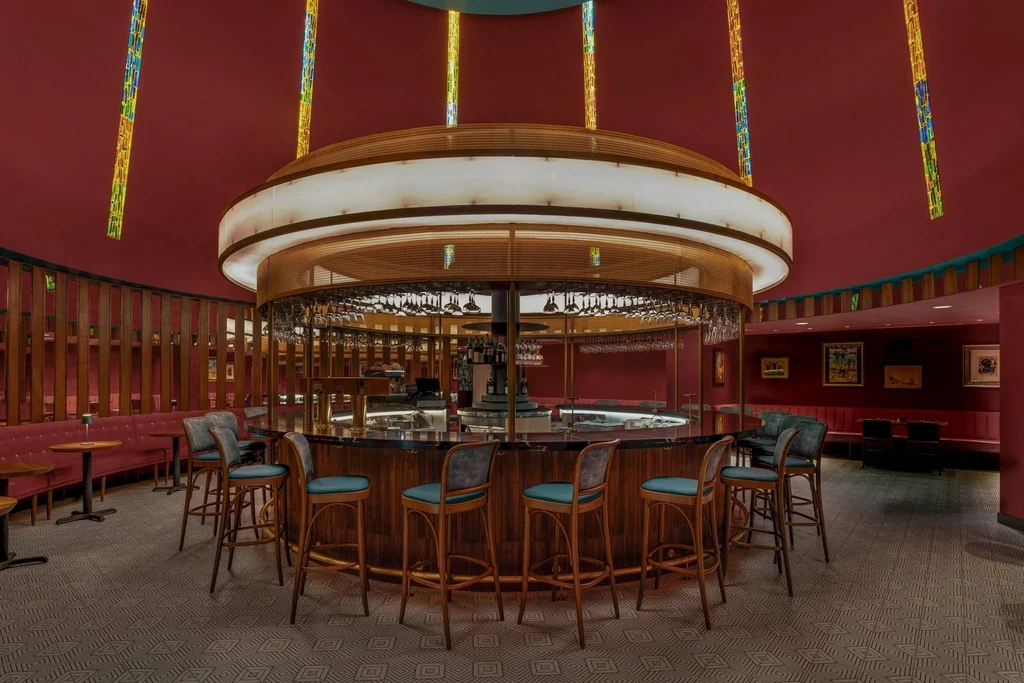 Elegant bar interior with a central circular bar and red ceiling.
