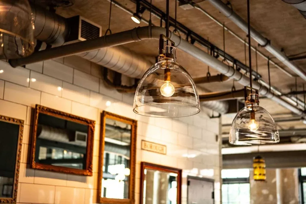 Modern industrial restaurant interior with warm lighting and subway tile wall.