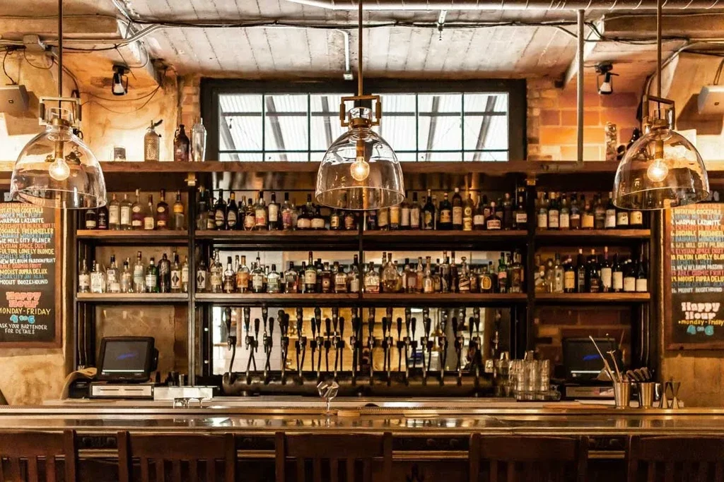 Well-stocked wooden bar, numerous beer taps, warm lighting, chalkboard menus.
