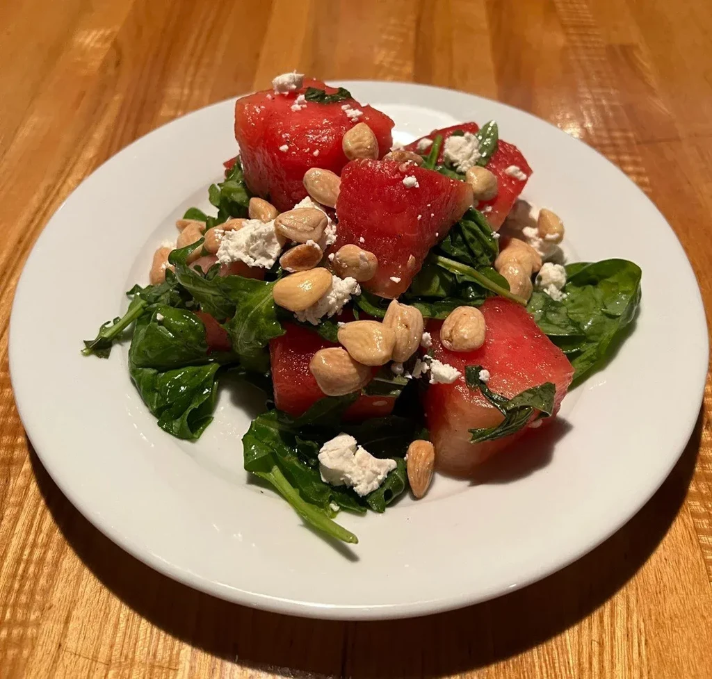 Watermelon, feta, leafy green salad with nuts and herbs.