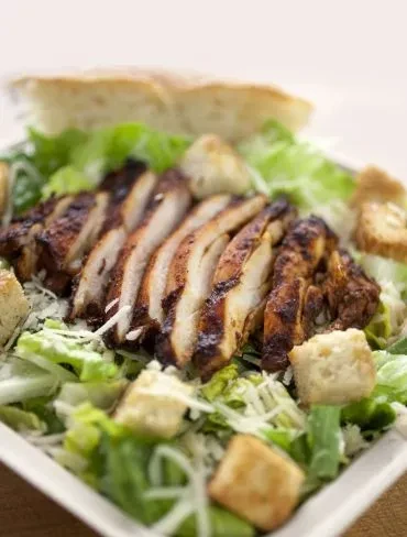 Caesar salad with grilled chicken, croutons, and grated cheese.