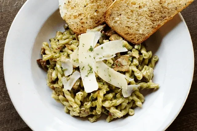 Cavatappi pasta with green pesto, chicken, parmesan, and toasted bread.